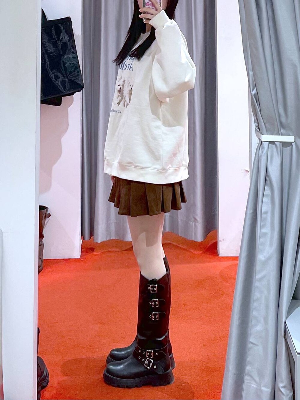 ベージュ系のダウンジャケット/コート、ブラック系のブーツ、ベージュ系のスウェットを着用したレディースの冬コーディネートの2枚目の写真