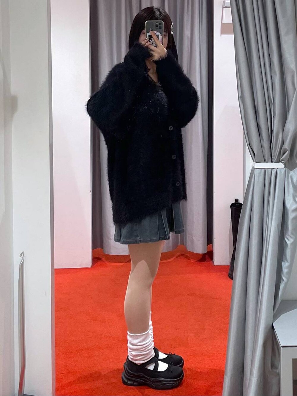 ブルー系のデニムスカート、ブラック系のカーディガン/ボレロを着用したレディースの秋コーディネートの2枚目の写真