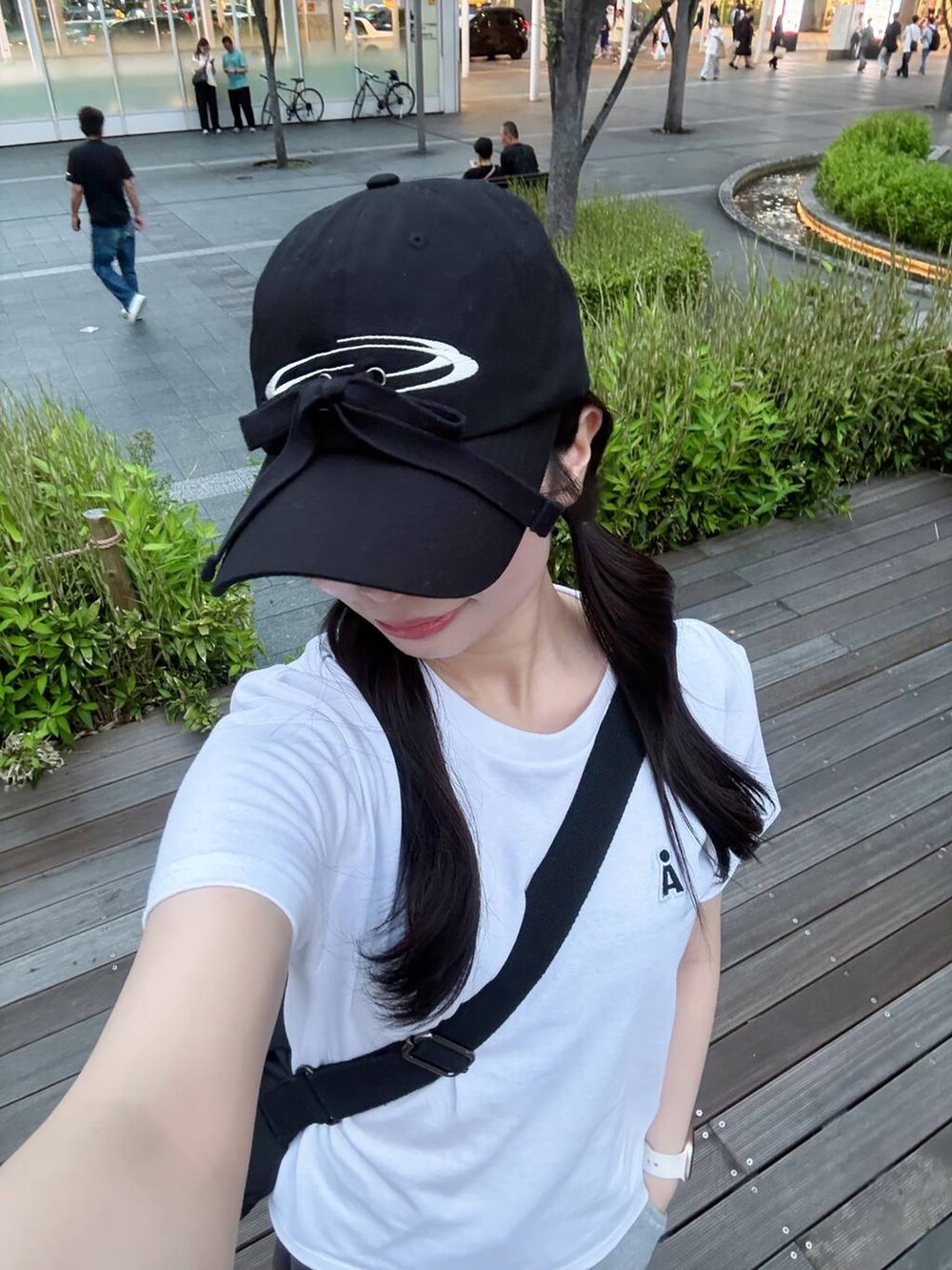 ホワイト系のTシャツ/カットソー、ブラック系のショルダーバッグ、ブラック系のキャップを着用したレディースの夏コーディネートの2枚目の写真