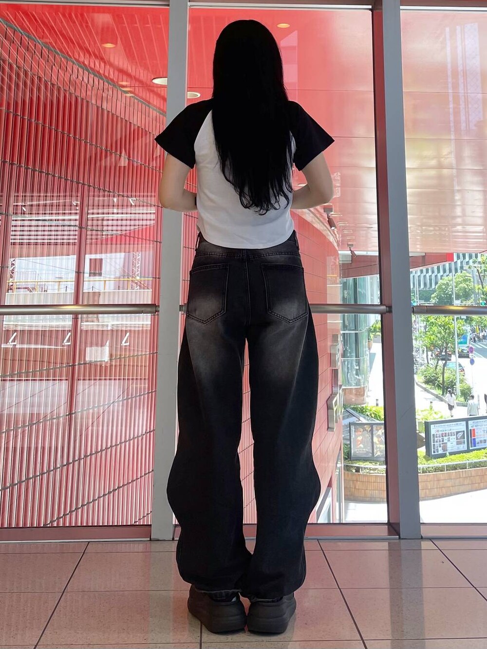 ブラック系のデニムパンツ、ブラック系のサンダルを着用したレディースの夏コーディネートの2枚目の写真