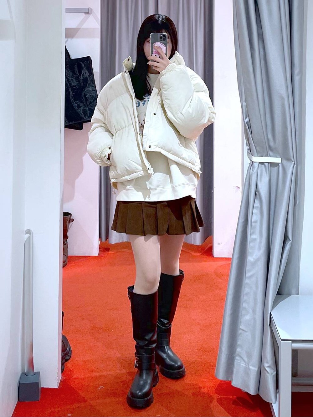 ベージュ系のダウンジャケット/コート、ブラック系のブーツ、ベージュ系のスウェットを着用したレディースの冬コーディネートの3枚目の写真