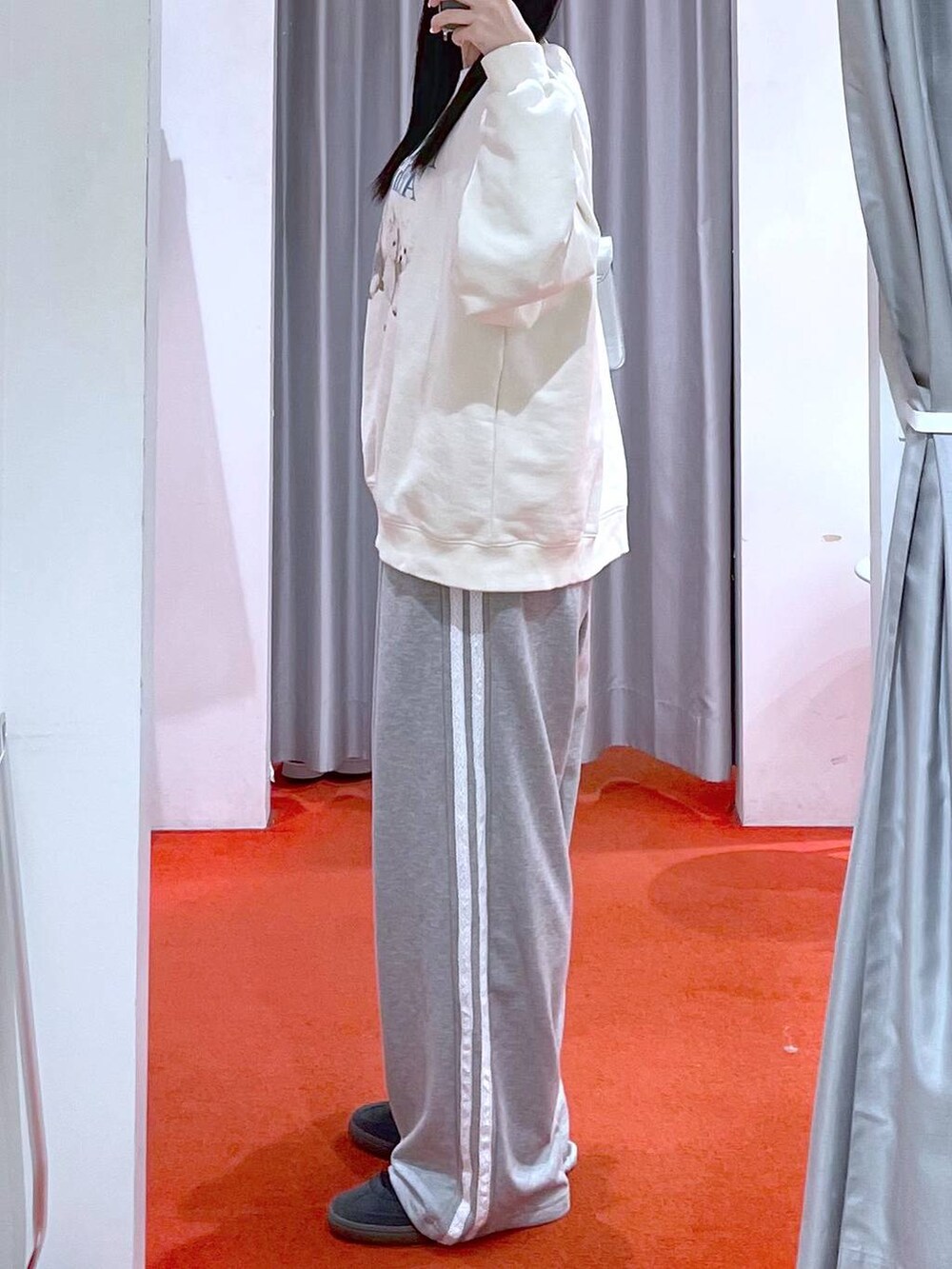 シルバー系のショルダーバッグ、ベージュ系のスウェット、ブラック系のスニーカーを着用したレディースの冬コーディネートの2枚目の写真