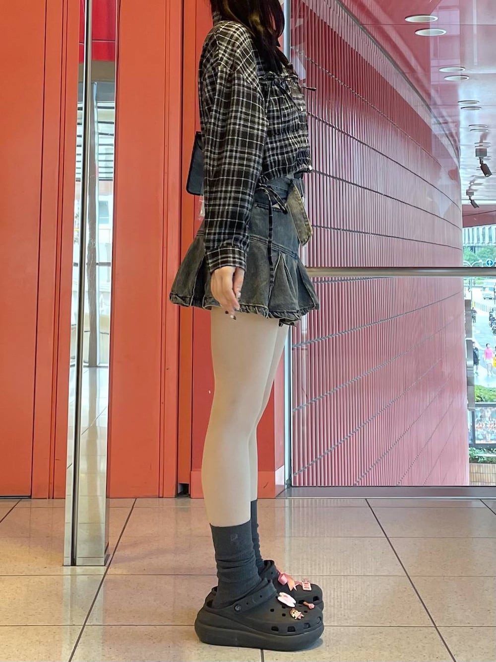 ブラック系のサンダル、ブルー系のデニムスカート、ブラック系のショルダーバッグを着用したレディースの秋コーディネートの2枚目の写真