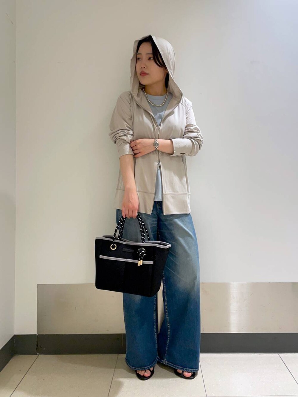 グリーン系のTシャツ/カットソー、グレー系のパーカー、ブラック系のトートバッグを着用したレディースの春コーディネートの2枚目の写真