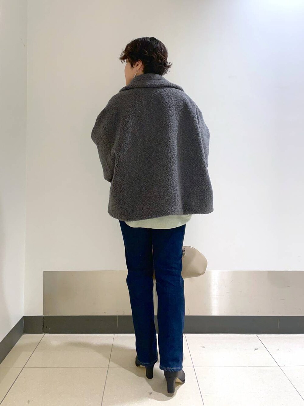 ベージュ系のトートバッグ、グリーン系のニット/セーター、グレー系のピーコートを着用したレディースの秋コーディネートの4枚目の写真