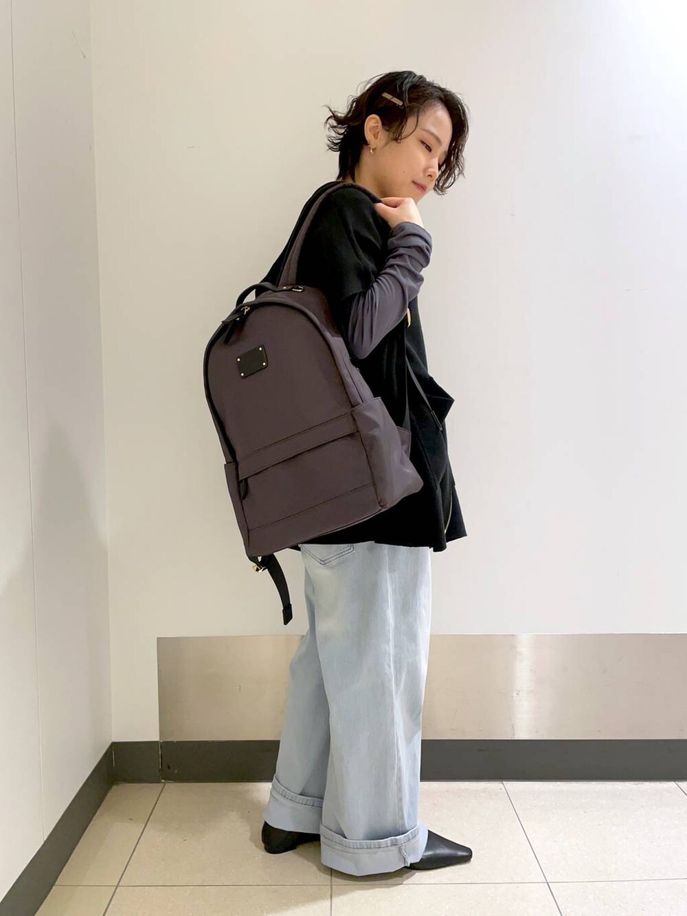 グレー系のバックパック/リュック、ブラック系のベスト、グレー系のTシャツ/カットソーを着用したレディースの冬コーディネートの2枚目の写真