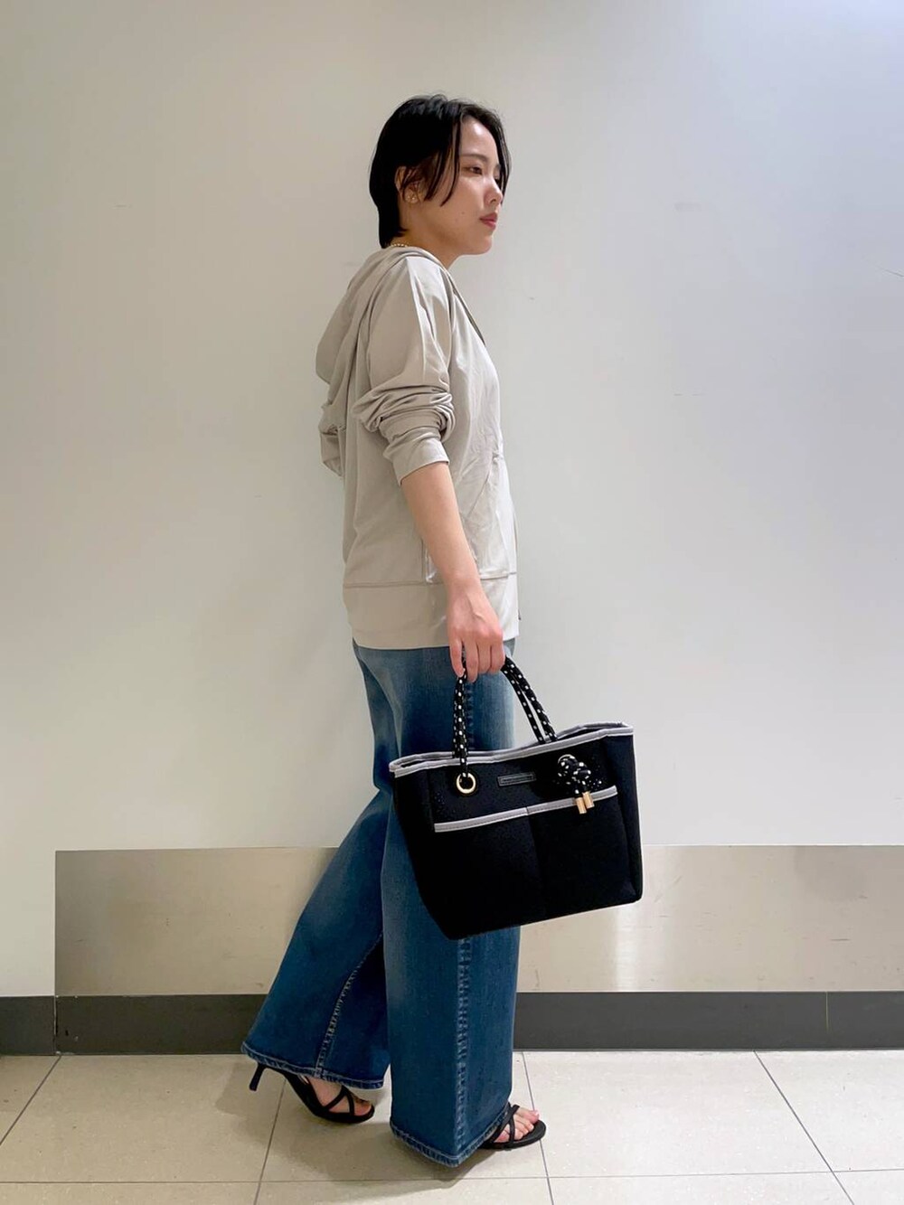 グリーン系のTシャツ/カットソー、グレー系のパーカー、ブラック系のトートバッグを着用したレディースの春コーディネートの3枚目の写真