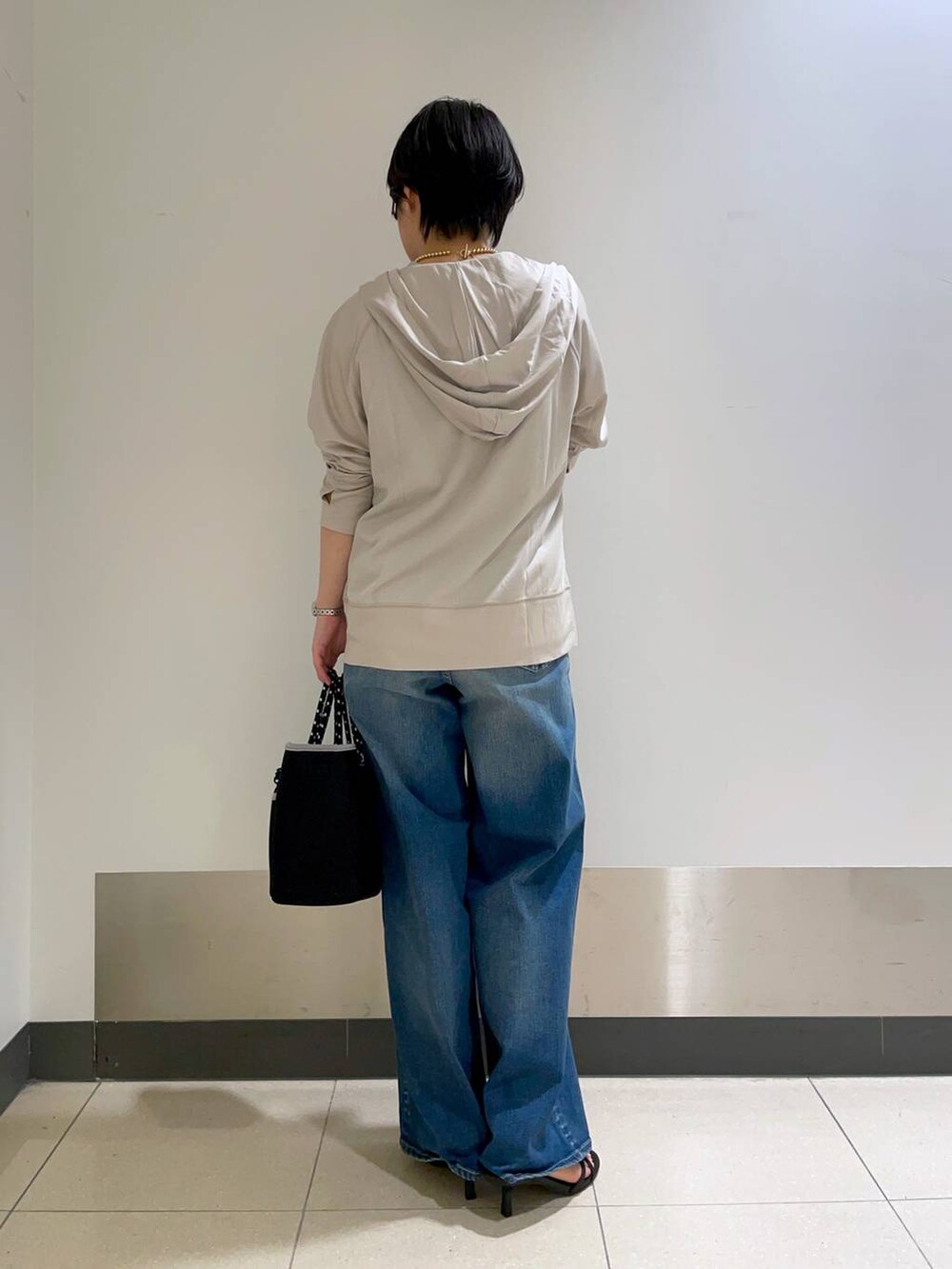 グリーン系のTシャツ/カットソー、グレー系のパーカー、ブラック系のトートバッグを着用したレディースの春コーディネートの4枚目の写真