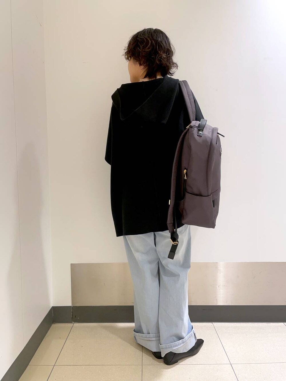 グレー系のバックパック/リュック、ブラック系のベスト、グレー系のTシャツ/カットソーを着用したレディースの冬コーディネートの3枚目の写真