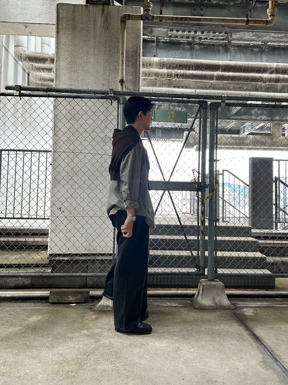 グリーン系のシャツ/ブラウス、ブラウン系のニット/セーター、ブラック系のデニムパンツを着用したメンズの秋コーディネートの2枚目の写真