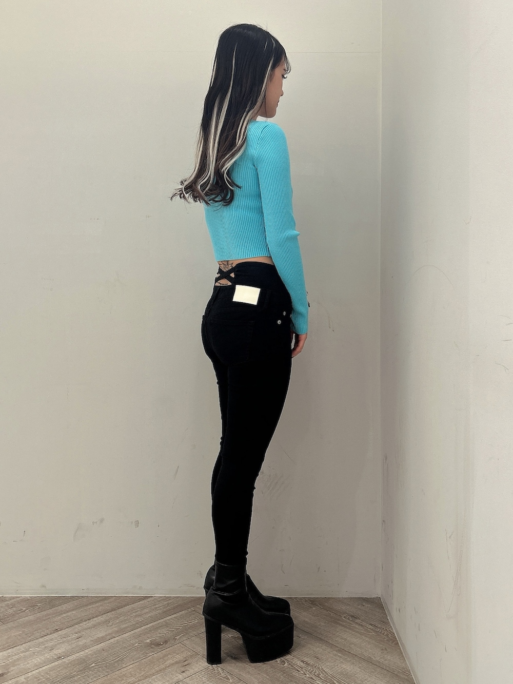 ブルー系のニット/セーター、ブラック系のデニムパンツ、ブラック系のブーツを着用したレディースの冬コーディネートの3枚目の写真