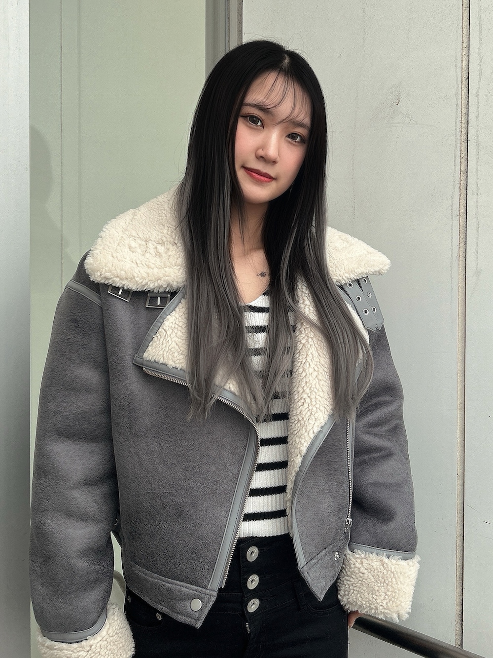 グレー系のライダースジャケット、ブラック系のデニムパンツ、その他のニット/セーターを着用したレディースの秋コーディネートの2枚目の写真