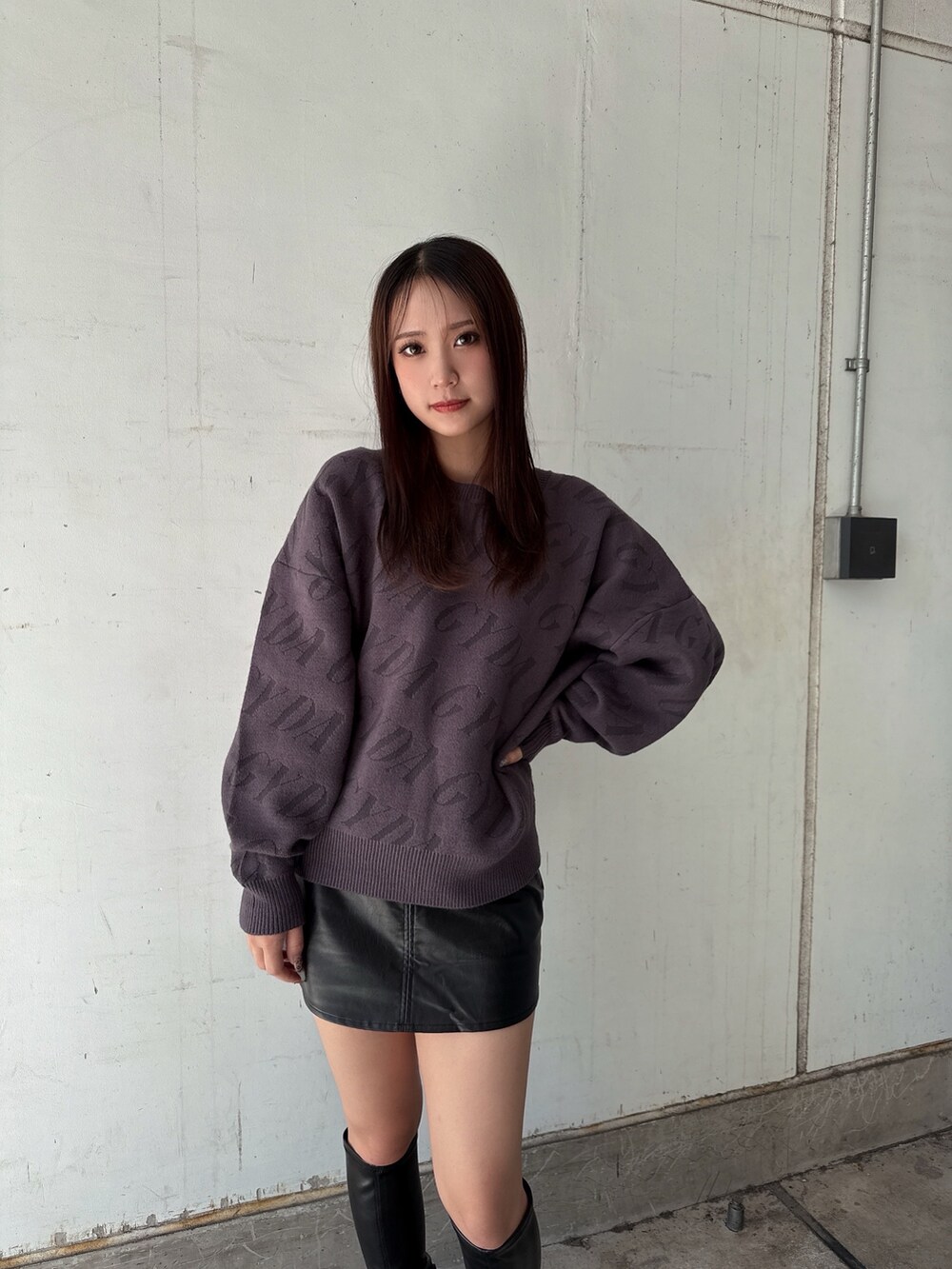 グレー系のニット/セーター、ブラック系のスカート、ブラック系のブーツを着用したレディースの秋コーディネートの4枚目の写真