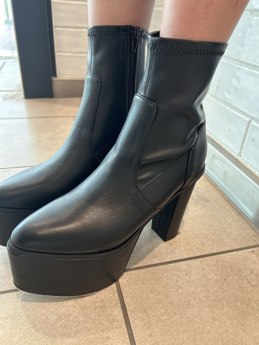 ブルー系のデニムパンツ、レッド系のニット/セーター、ブラック系のブーツを着用したレディースの秋コーディネートの8枚目の写真