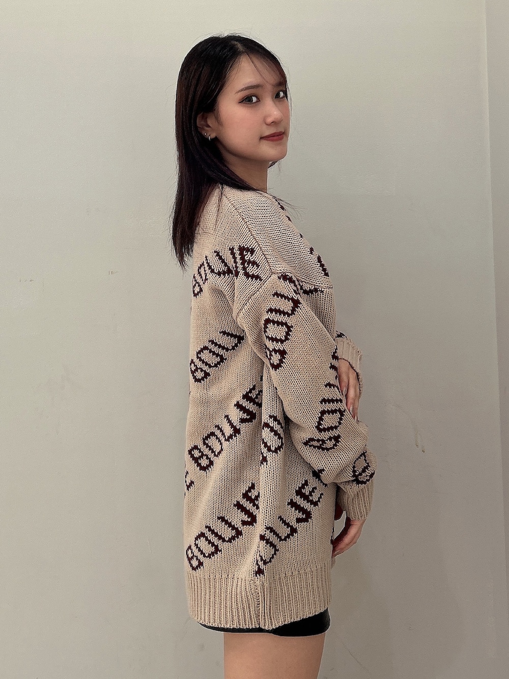 ベージュ系のニット/セーター、ブラック系のスカート、ブラック系のブーツを着用したレディースの秋コーディネートの4枚目の写真