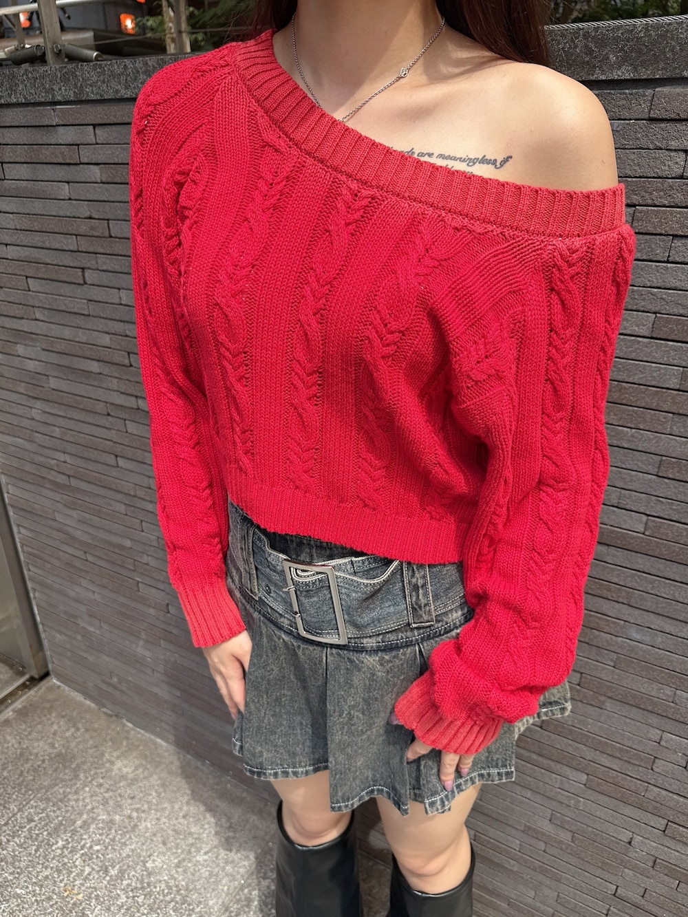 レッド系のニット/セーター、ブルー系のデニムスカート、ブラック系のブーツを着用したレディースの秋コーディネートの7枚目の写真