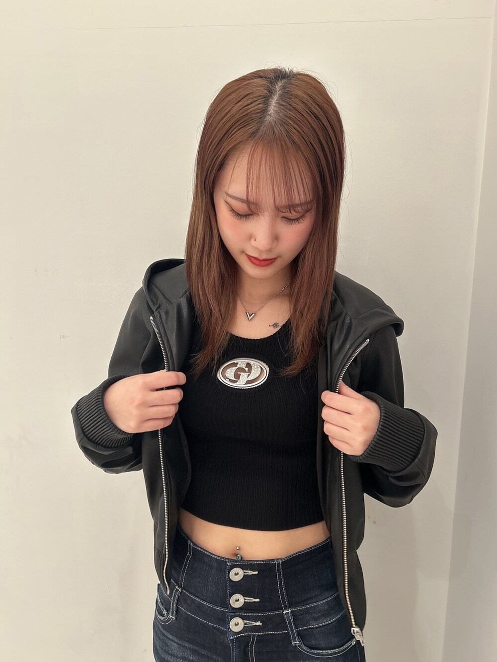 ブラック系のニット/セーター、ブラック系のブルゾン、ブルー系のデニムパンツを着用したレディースの春コーディネートの5枚目の写真