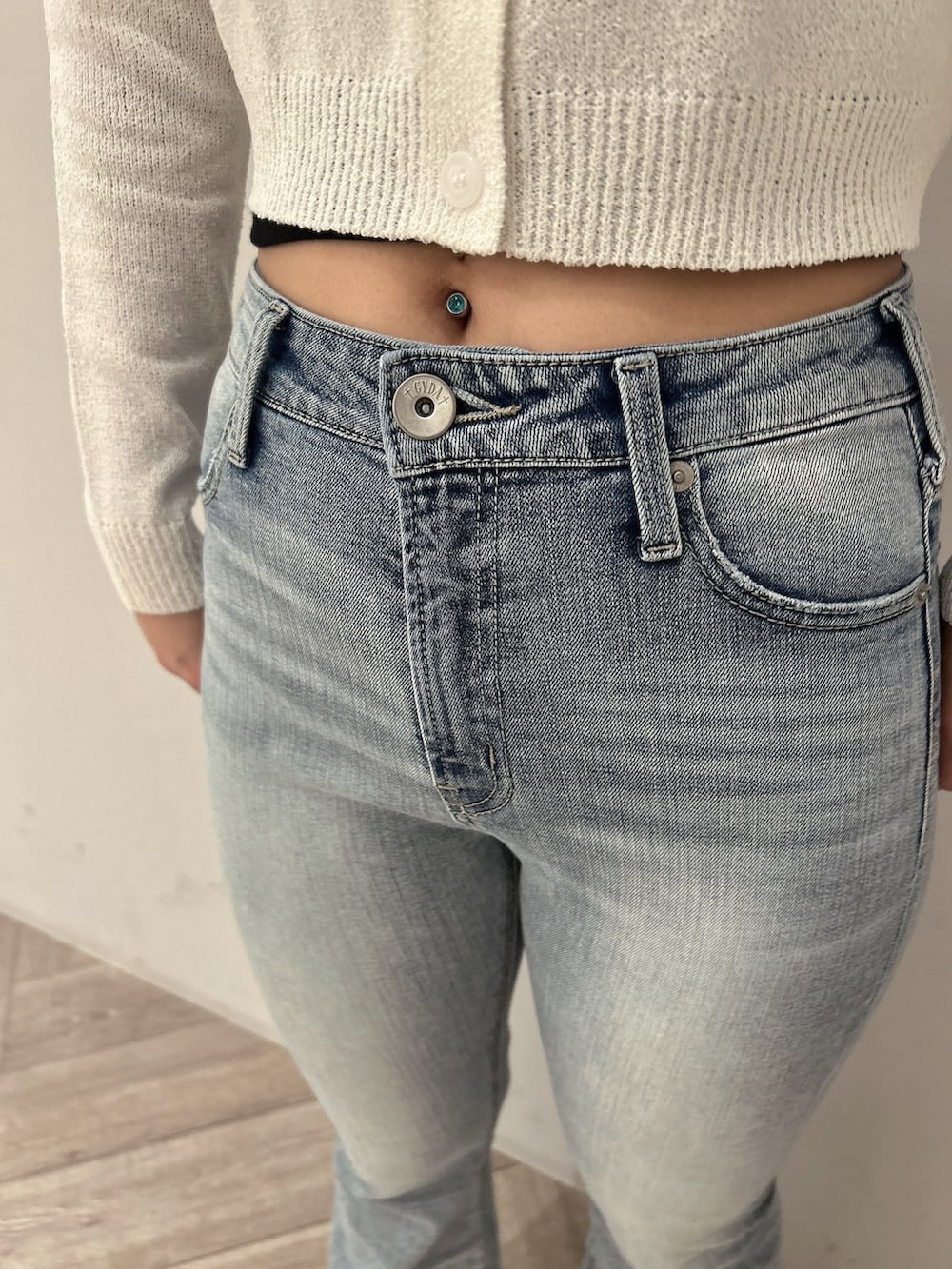 ホワイト系のカーディガン/ボレロ、ブラック系のキャミソール、ブルー系のデニムパンツを着用したレディースの春コーディネートの7枚目の写真