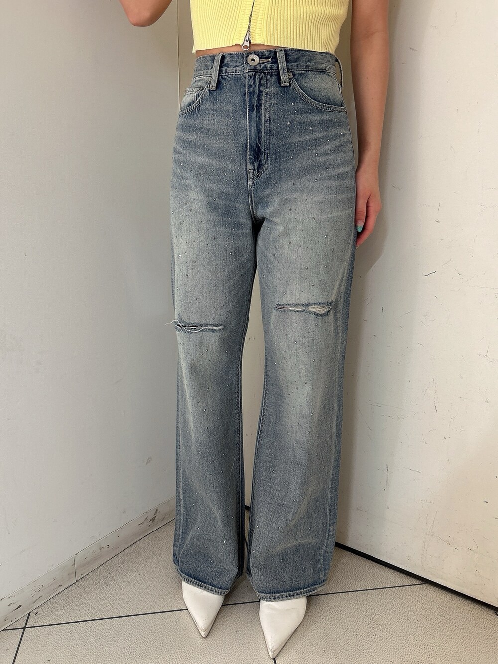 イエロー系のニット/セーター、ブルー系のデニムパンツ、ホワイト系のパンプスを着用したレディースの春コーディネートの7枚目の写真