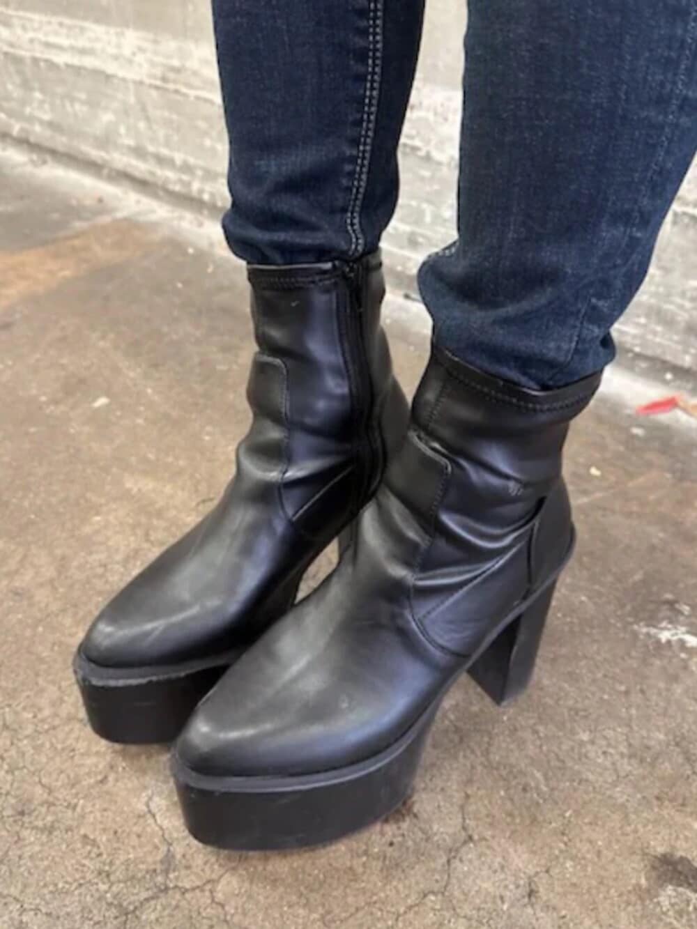 ブラック系のブーツ、ホワイト系のニット/セーター、ブルー系のデニムパンツを着用したレディースの冬コーディネートの9枚目の写真