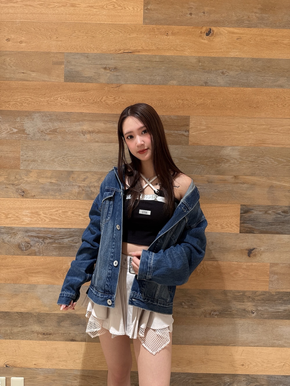 ブルー系のデニムジャケット、ブラック系のTシャツ/カットソー、ホワイト系のスカートを着用したレディースの春コーディネートの4枚目の写真