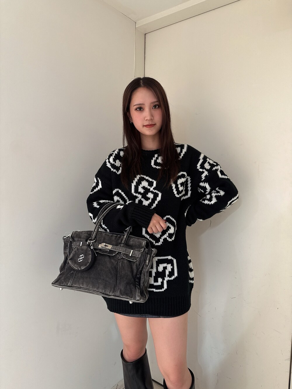 ブラック系のニット/セーター、ブラック系のスカート、ブラック系のブーツを着用したレディースの秋コーディネートの5枚目の写真