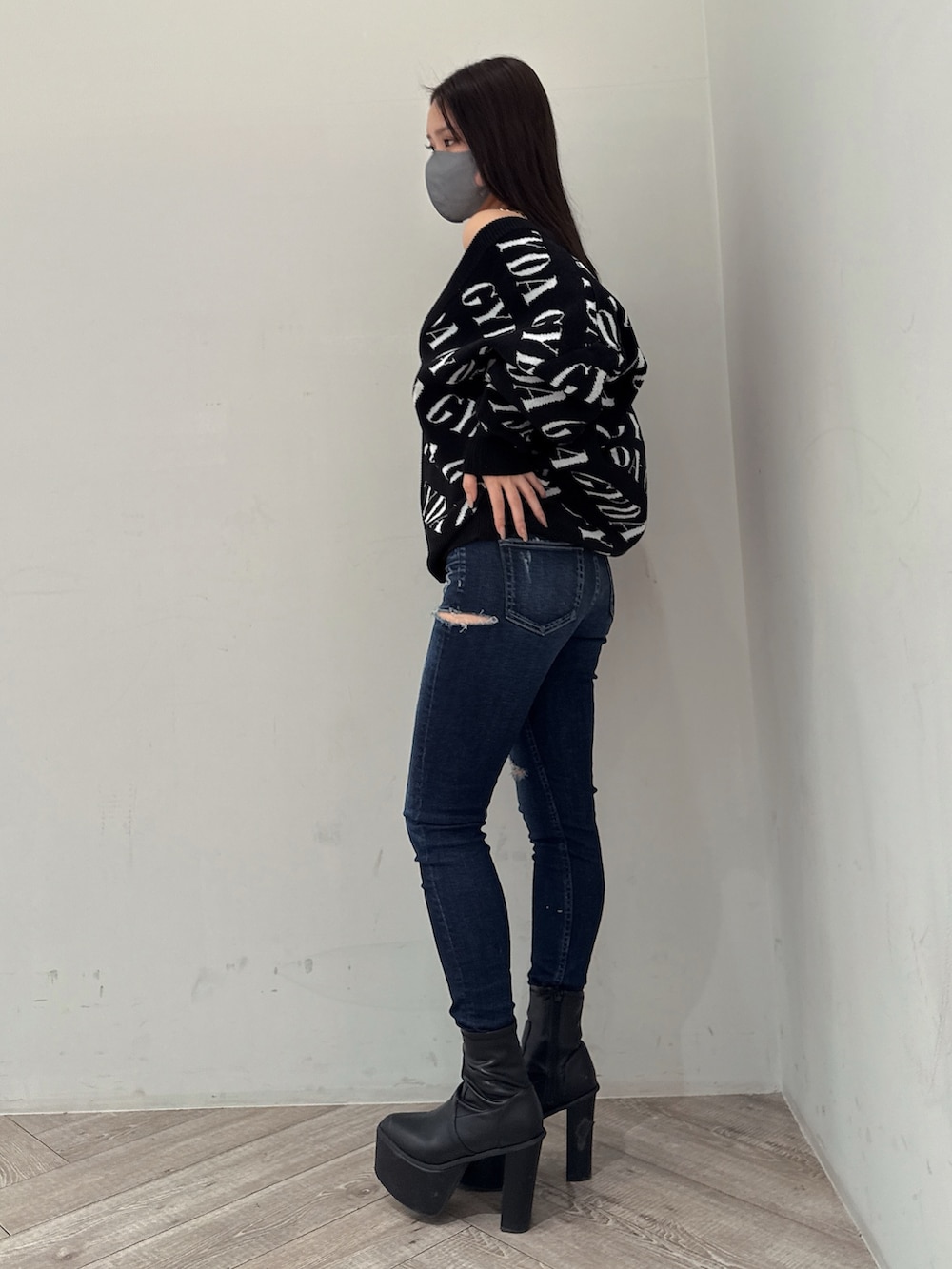 ブラック系のカーディガン/ボレロ、ホワイト系のキャミソール、ブルー系のデニムパンツを着用したレディースの春コーディネートの2枚目の写真