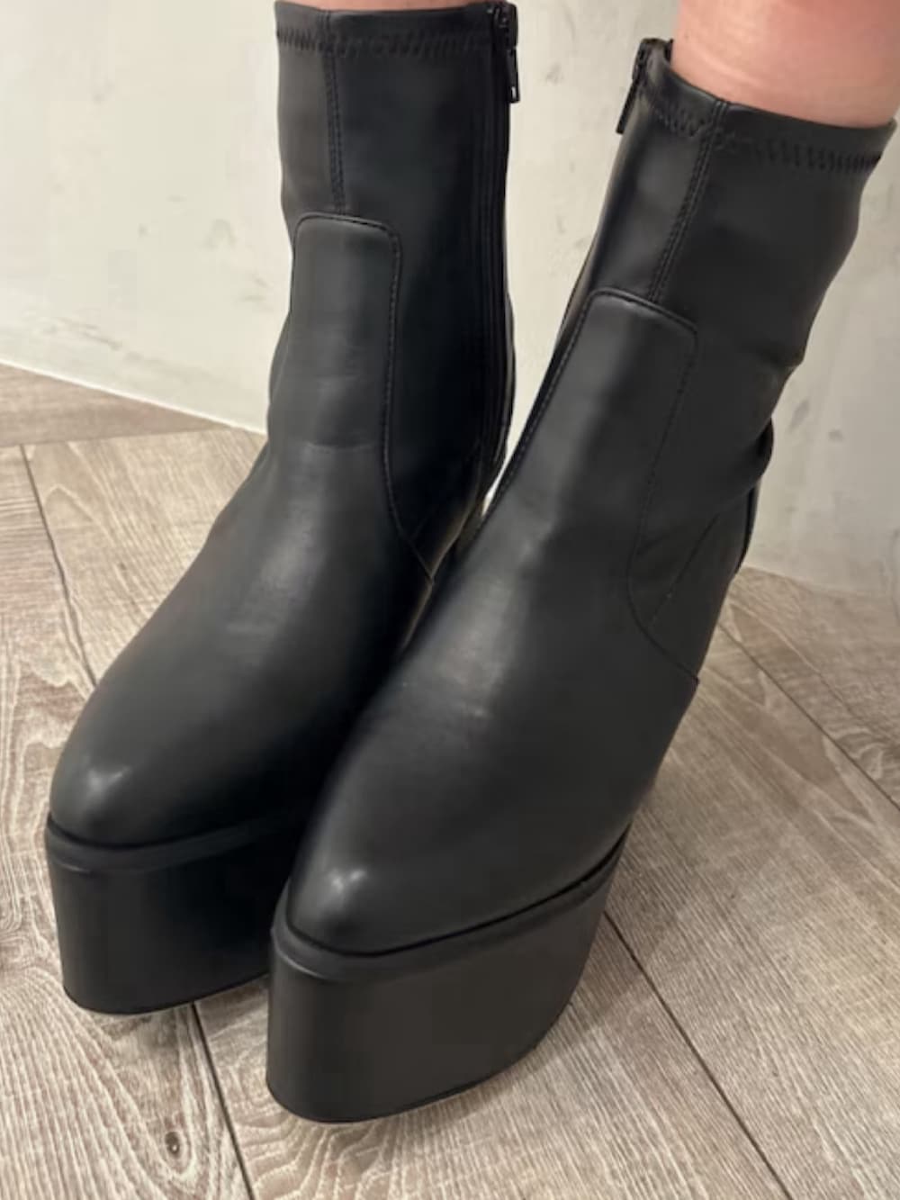 グレー系のスウェット、ブラック系のデニムパンツ、ブラック系のブーツを着用したレディースの冬コーディネートの7枚目の写真