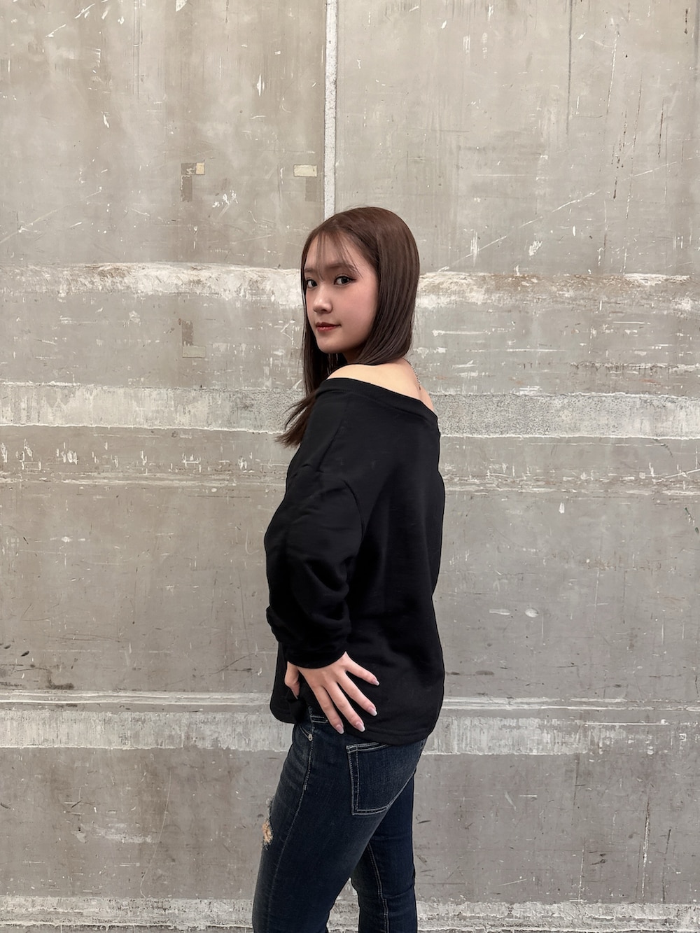 ブラック系のムートンコート、ブラック系のスウェット、ブルー系のデニムパンツを着用したレディースの秋コーディネートの5枚目の写真