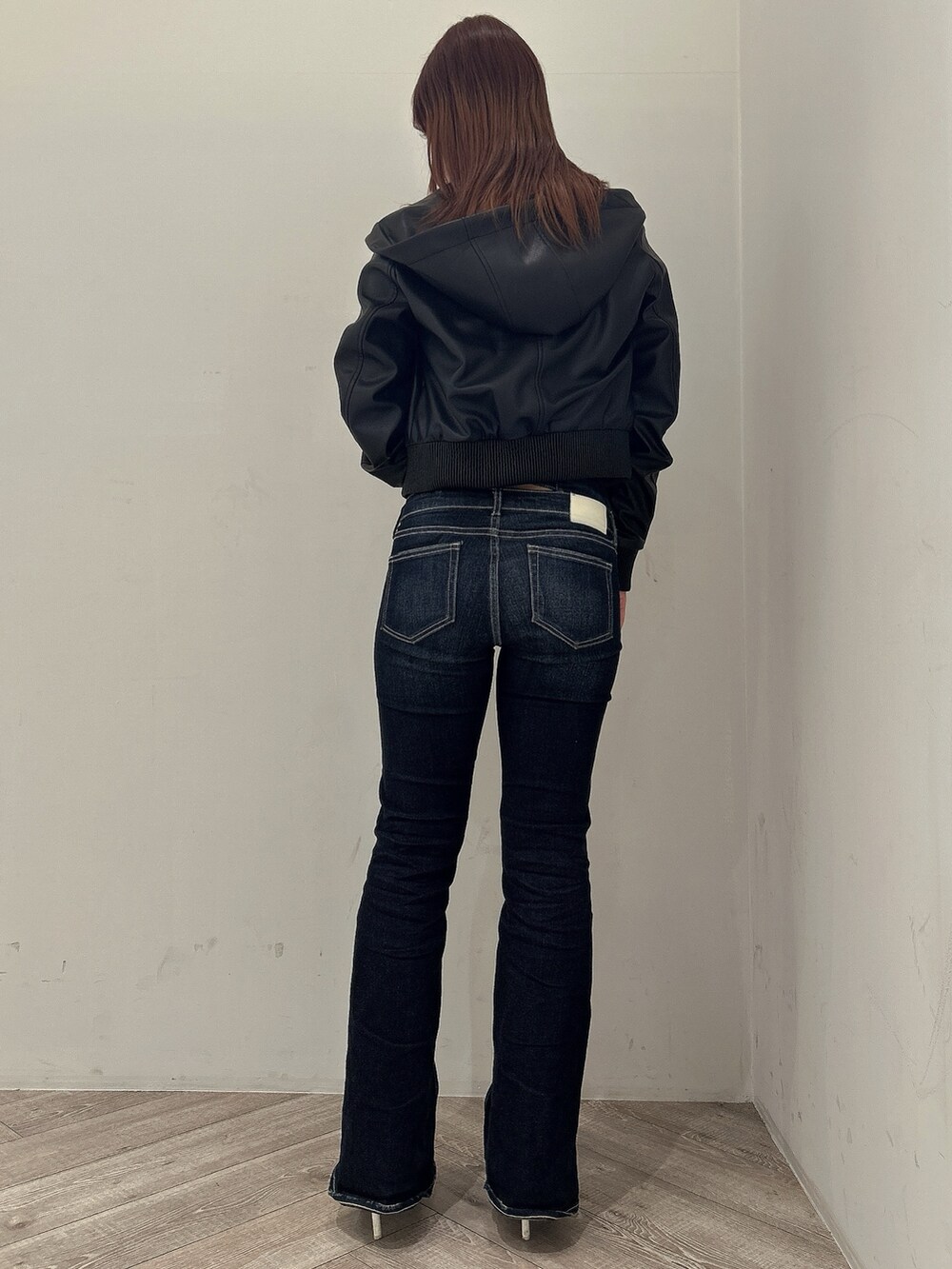 ブラック系のニット/セーター、ブラック系のブルゾン、ブルー系のデニムパンツを着用したレディースの春コーディネートの3枚目の写真