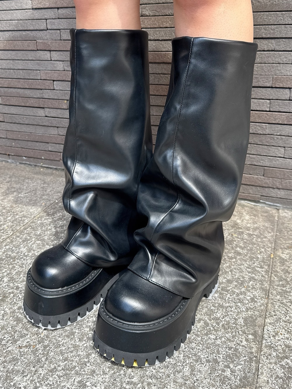 レッド系のニット/セーター、ブルー系のデニムスカート、ブラック系のブーツを着用したレディースの秋コーディネートの9枚目の写真