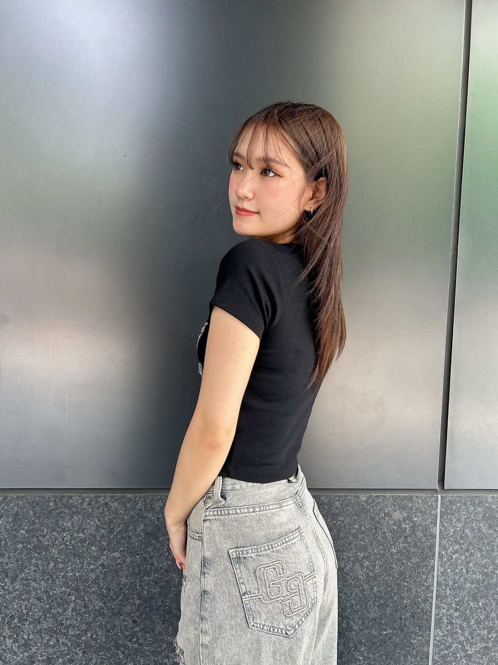 ブラック系のTシャツ/カットソー、ブルー系のデニムパンツ、ブラック系のサンダルを着用したレディースの夏コーディネートの5枚目の写真