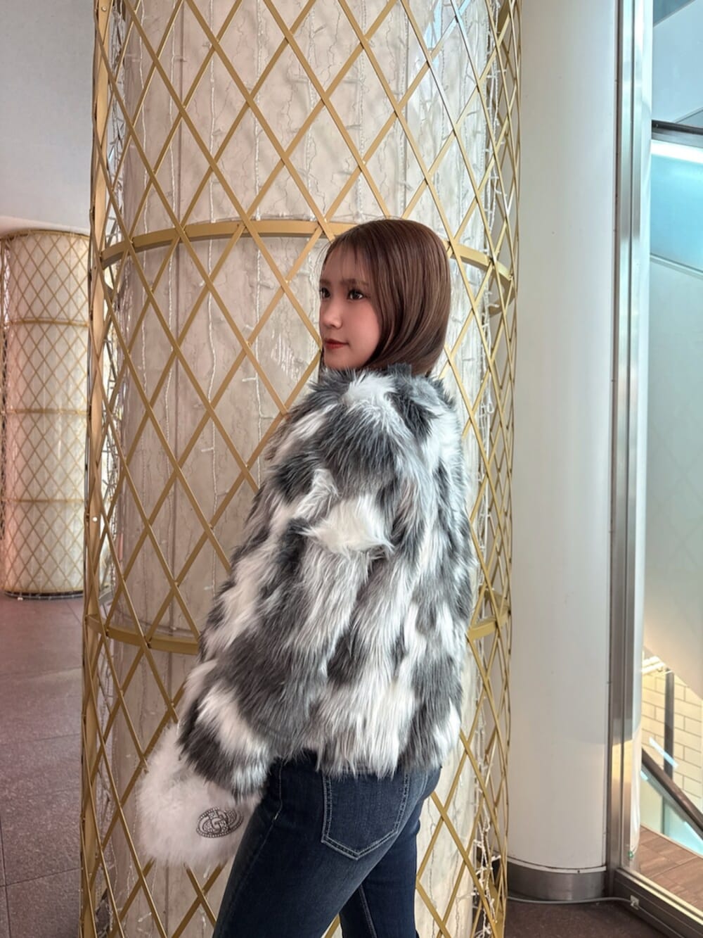 ブラック系のブーツ、ホワイト系のニット/セーター、その他のライダースジャケットを着用したレディースの冬コーディネートの5枚目の写真