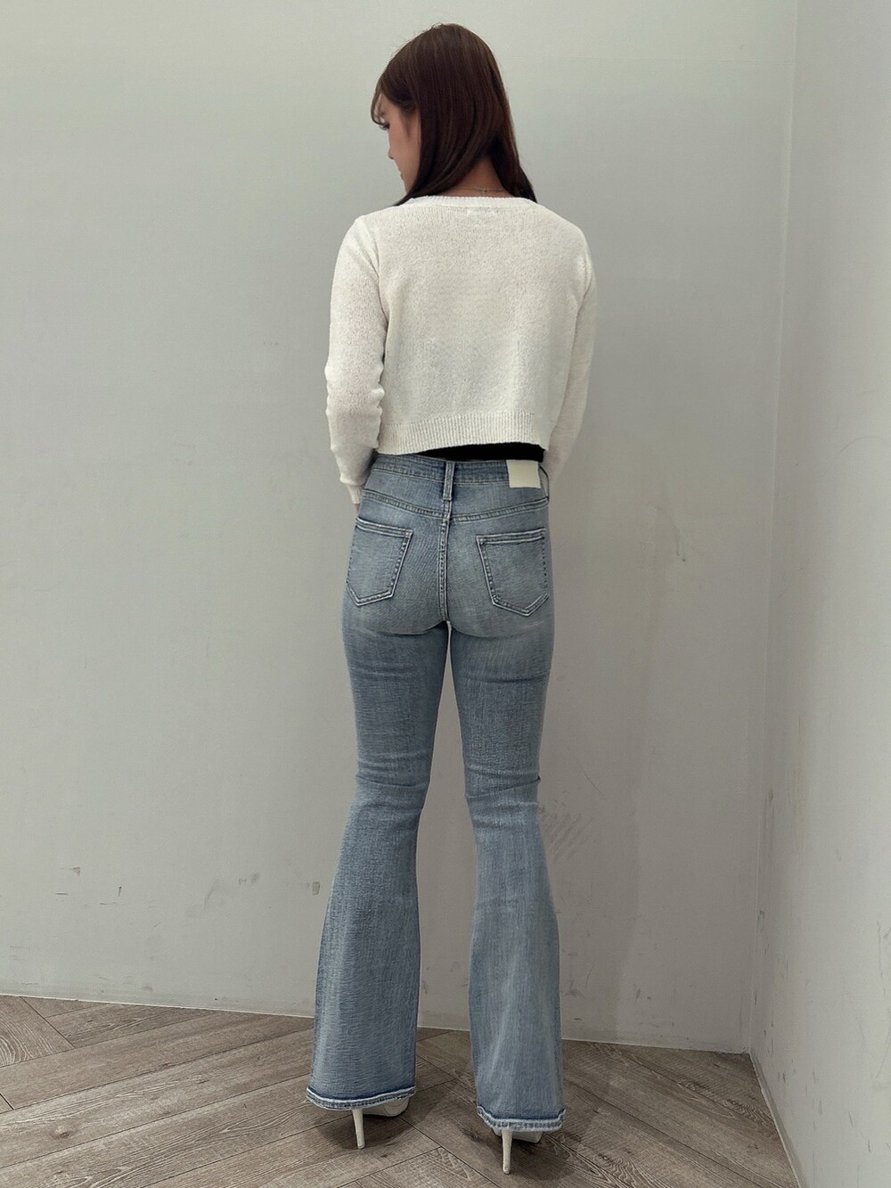 ホワイト系のカーディガン/ボレロ、ブラック系のキャミソール、ブルー系のデニムパンツを着用したレディースの春コーディネートの3枚目の写真