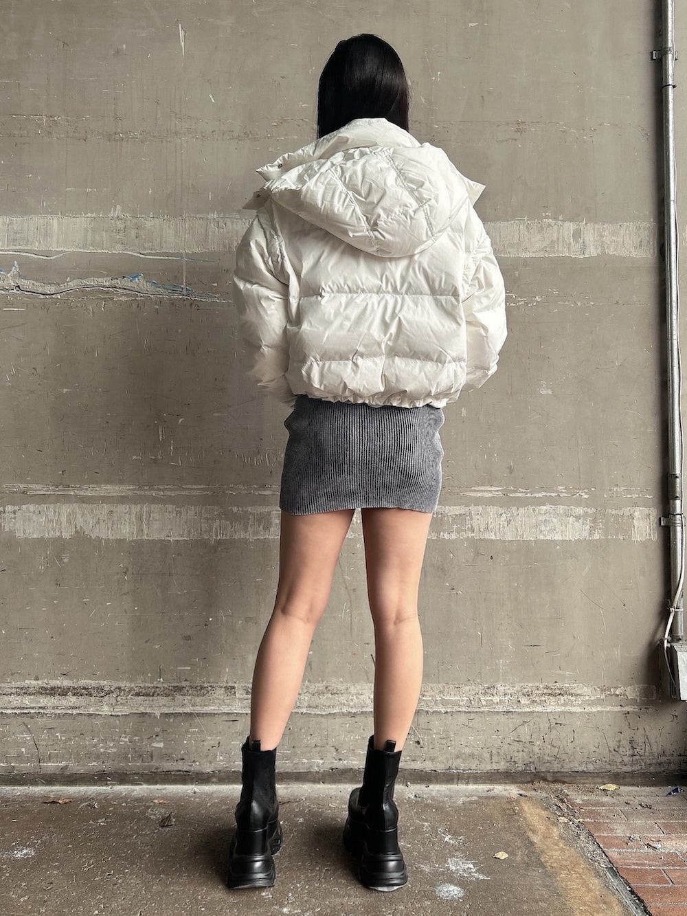 ブルー系のワンピース、ホワイト系のダウンジャケット/コート、ブラック系のブーツを着用したレディースの冬コーディネートの2枚目の写真