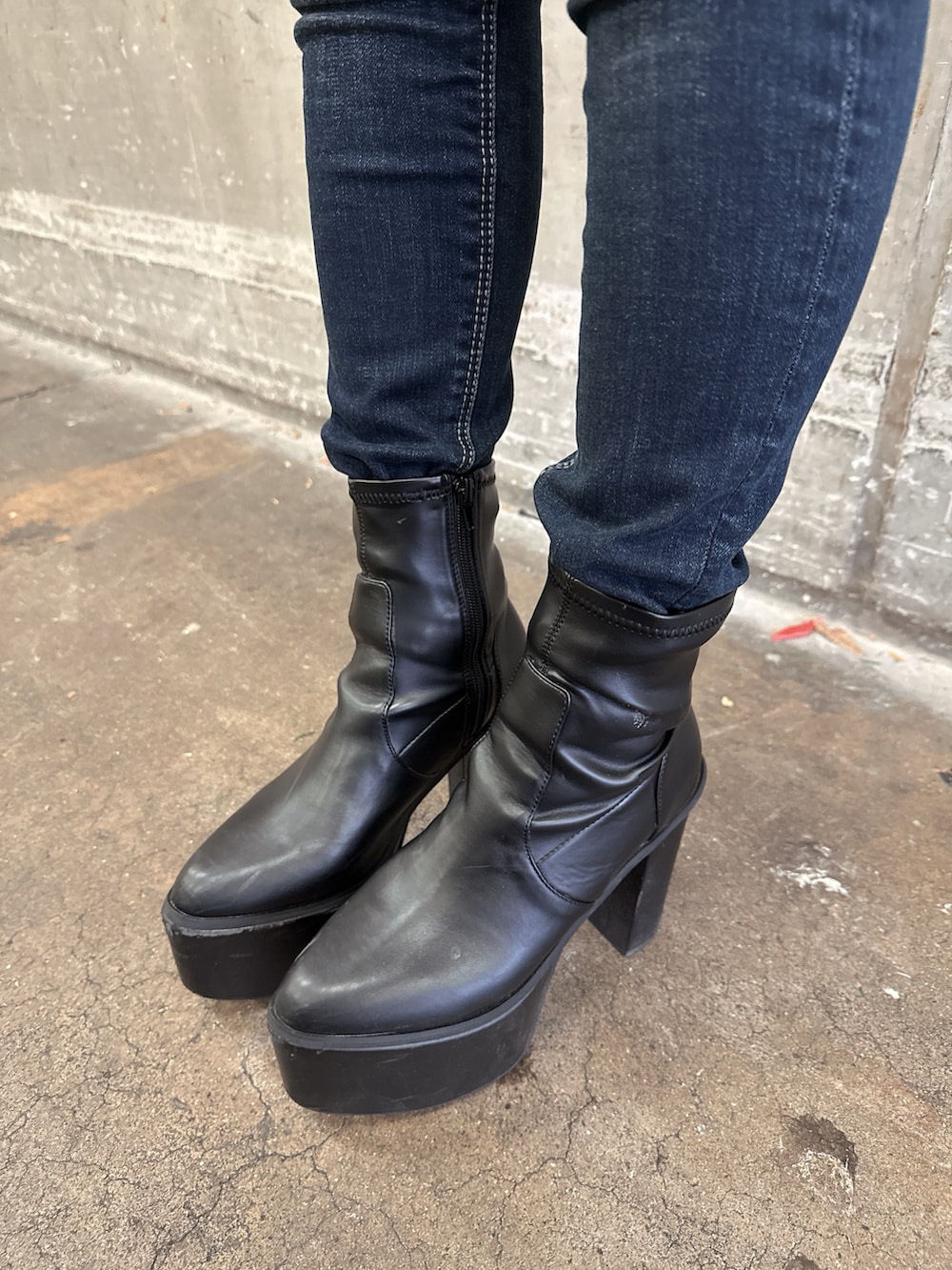 ブラック系のムートンコート、ブラック系のスウェット、ブルー系のデニムパンツを着用したレディースの秋コーディネートの9枚目の写真