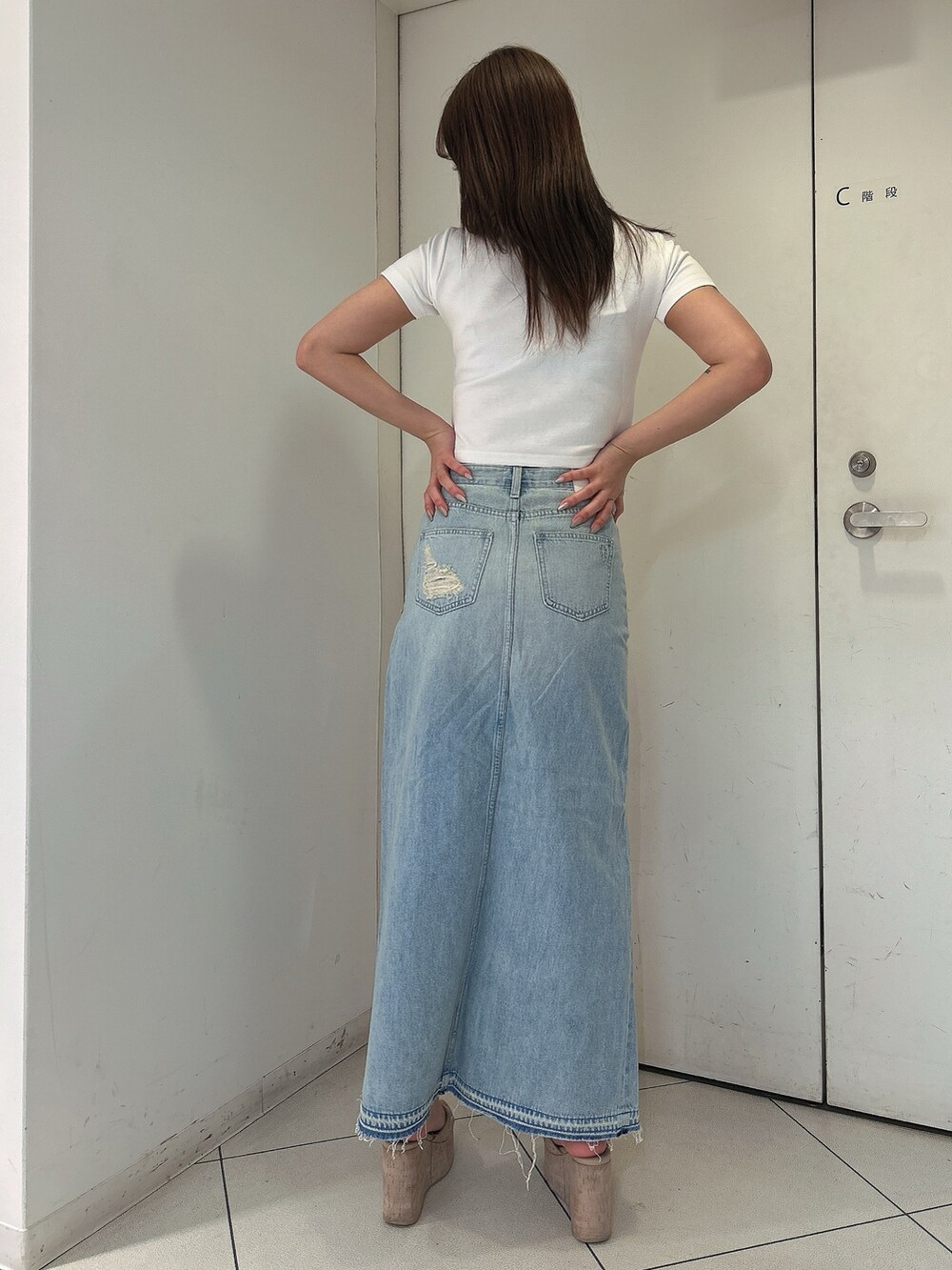 ホワイト系のTシャツ/カットソー、ブルー系のデニムスカート、ホワイト系のサンダルを着用したレディースの春コーディネートの3枚目の写真