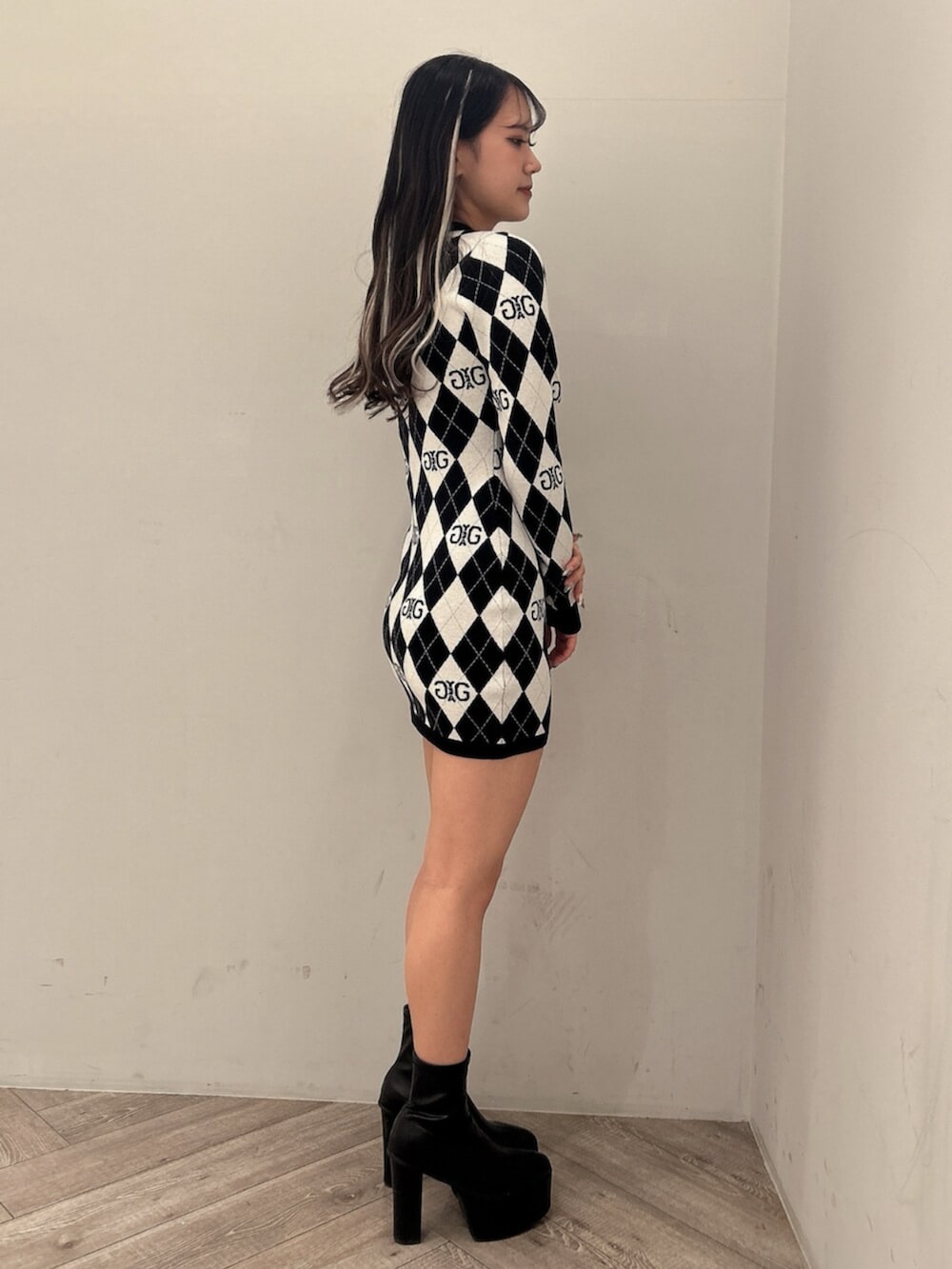 ブラック系のブーツ、ブラック系のワンピースを着用したレディースの冬コーディネートの2枚目の写真