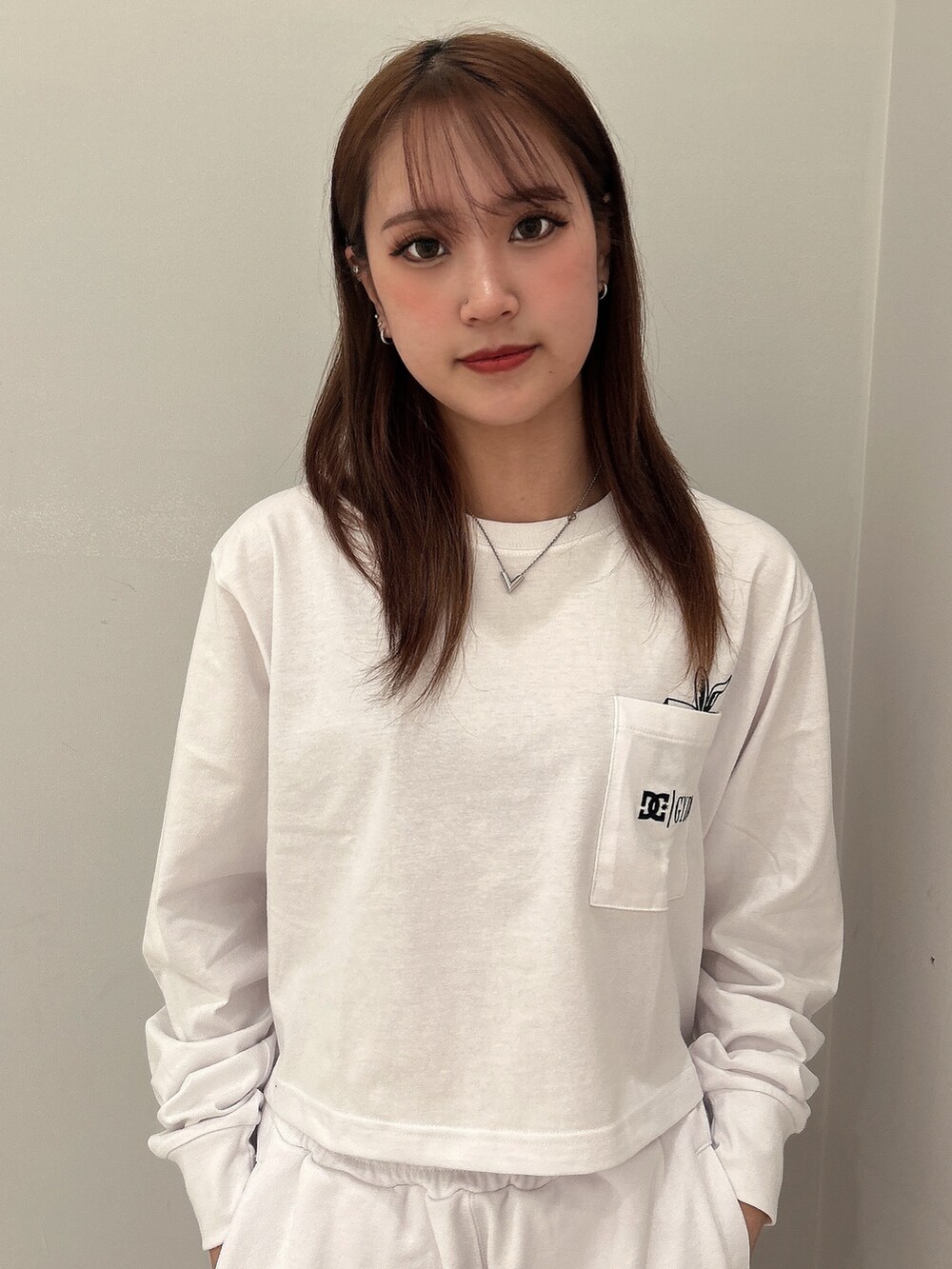 ホワイト系のTシャツ/カットソー、ホワイト系のスウェットパンツ、ブラック系のパンプスを着用したレディースの春コーディネートの4枚目の写真
