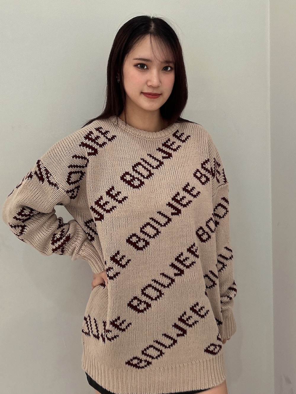 ベージュ系のニット/セーター、ブラック系のスカート、ブラック系のブーツを着用したレディースの秋コーディネートの3枚目の写真