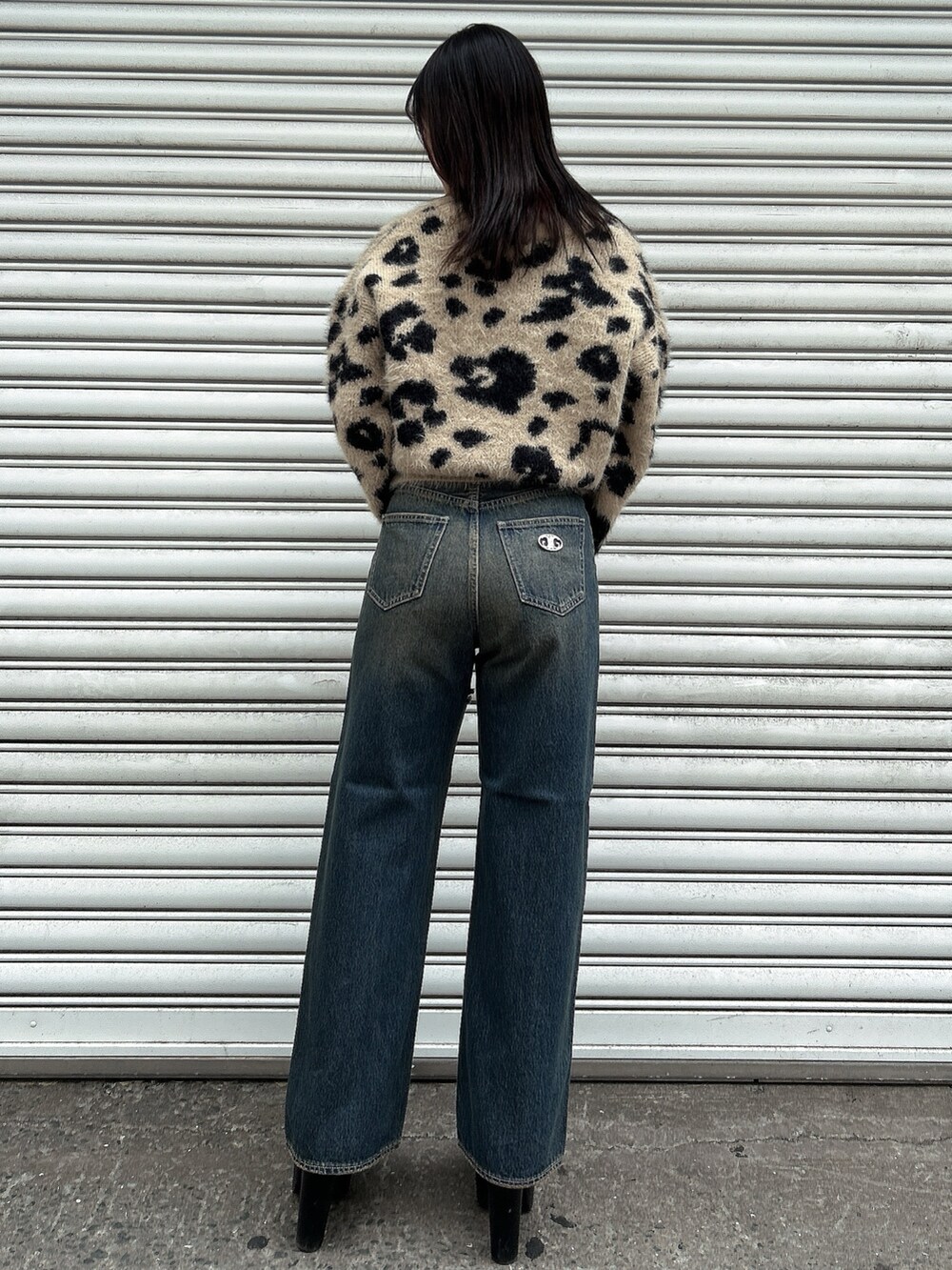 ホワイト系のニット/セーター、ブルー系のデニムパンツ、ブラック系のブーツを着用したレディースの冬コーディネートの3枚目の写真