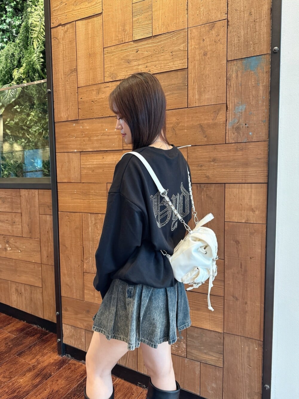 ブルー系のデニムスカート、ブラック系のブーツ、ブラック系のパーカーを着用したレディースの秋コーディネートの5枚目の写真