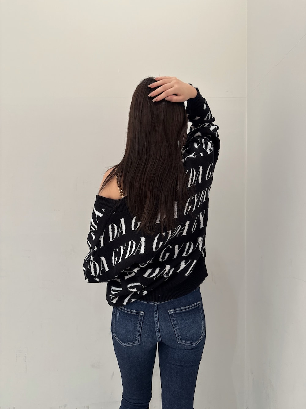 ブラック系のカーディガン/ボレロ、ホワイト系のキャミソール、ブルー系のデニムパンツを着用したレディースの春コーディネートの6枚目の写真