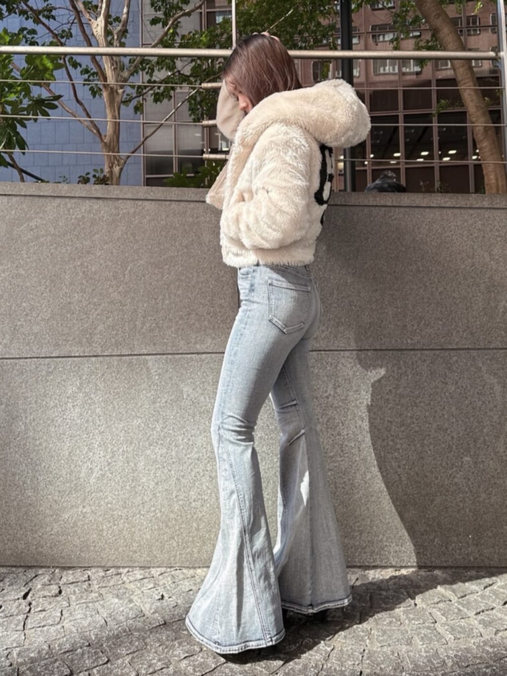 ブラック系のブーツ、ホワイト系のニット/セーター、ホワイト系のブルゾンを着用したレディースの秋コーディネートの2枚目の写真