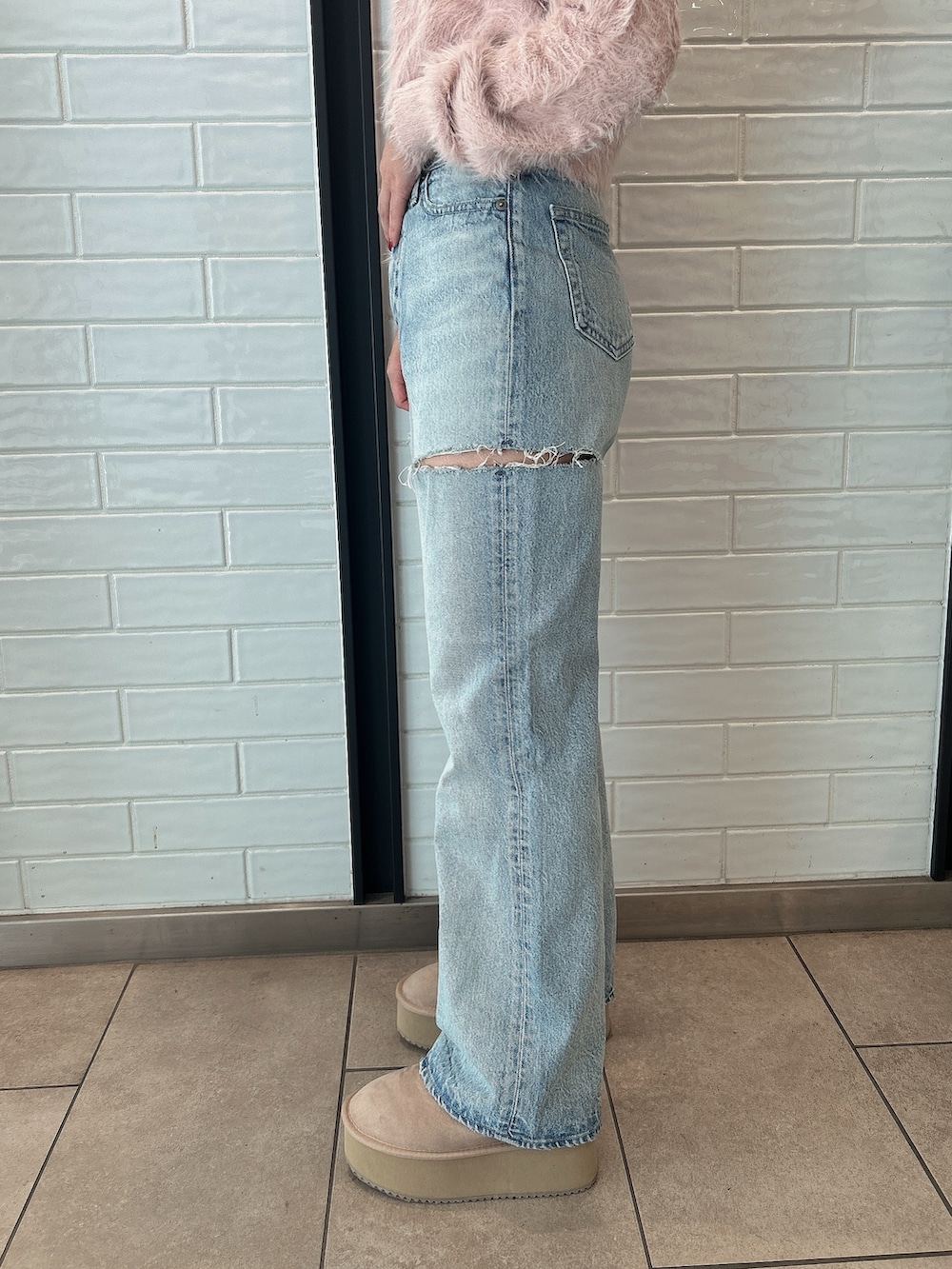 ピンク系のニット/セーター、ブルー系のデニムパンツ、ベージュ系のブーツを着用したレディースの冬コーディネートの8枚目の写真