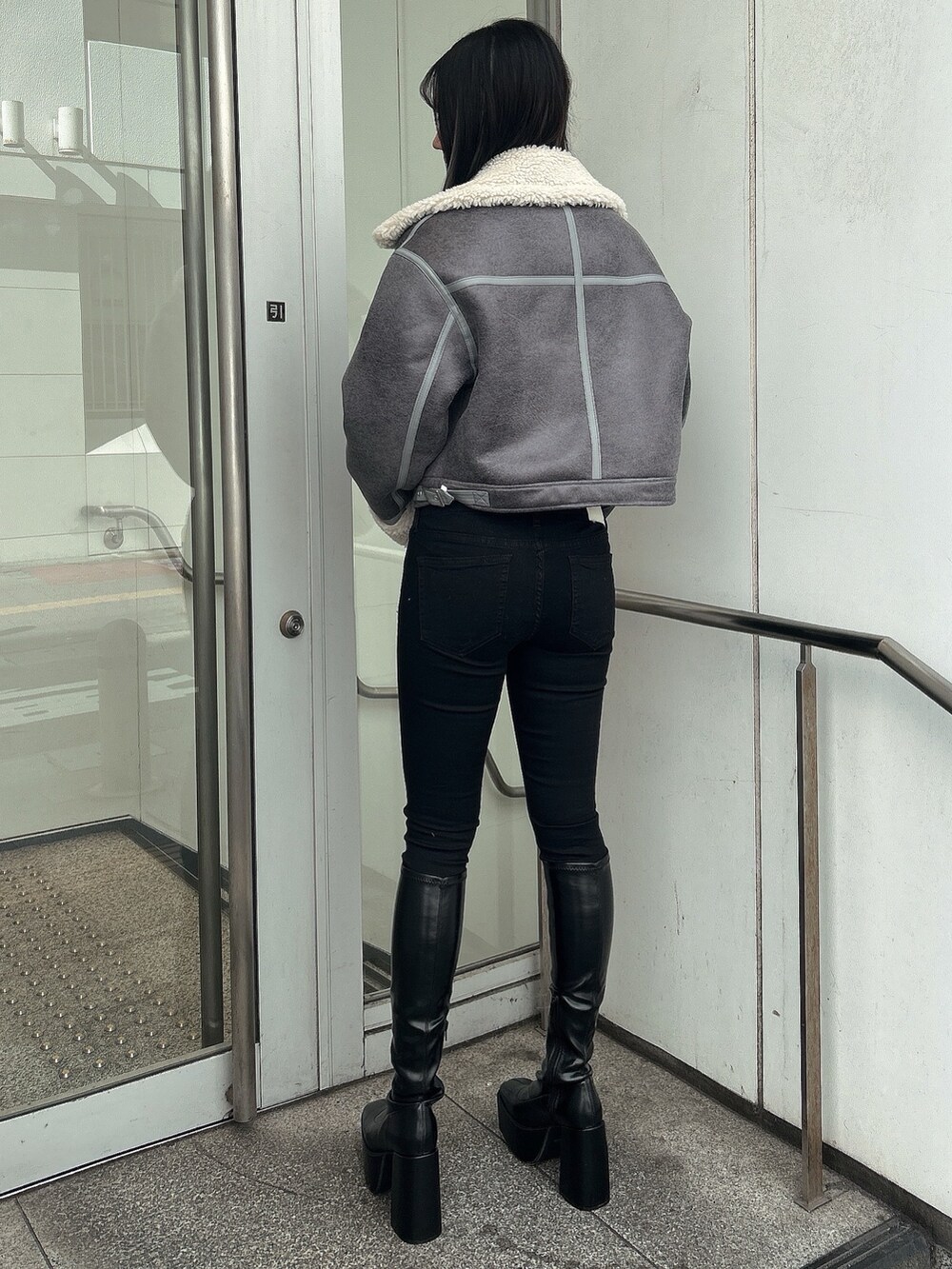 グレー系のライダースジャケット、ブラック系のデニムパンツ、その他のニット/セーターを着用したレディースの秋コーディネートの3枚目の写真