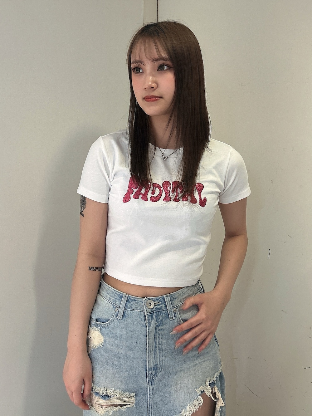 ホワイト系のTシャツ/カットソー、ブルー系のデニムスカート、ホワイト系のサンダルを着用したレディースの春コーディネートの4枚目の写真