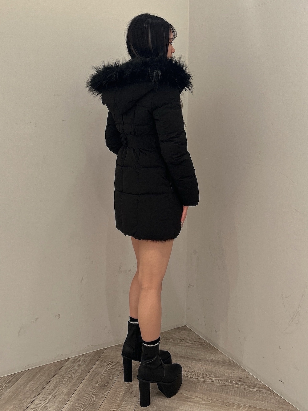 ブラック系のダウンジャケット/コート、ブラック系のワンピース、ブラック系のブーツを着用したレディースの秋コーディネートの6枚目の写真