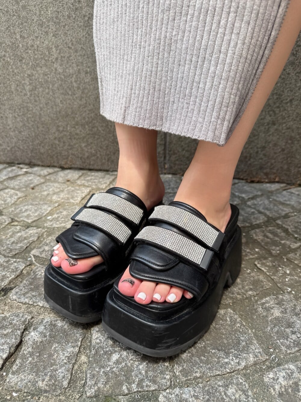 ブラック系のハンドバッグ、ブラック系のサンダル、グレー系のワンピースを着用したレディースの夏コーディネートの9枚目の写真