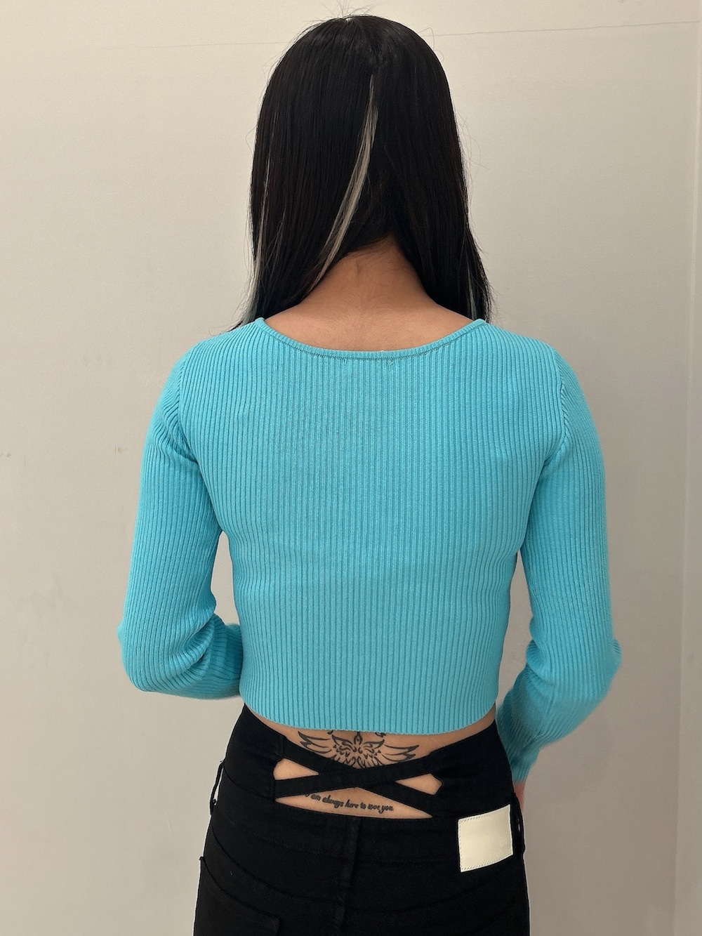 ブルー系のニット/セーター、ブラック系のデニムパンツ、ブラック系のブーツを着用したレディースの冬コーディネートの6枚目の写真